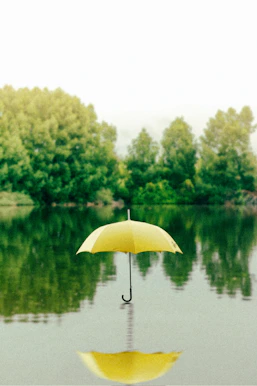 yellow umbrella on surface of water at daytime representing covering those you love