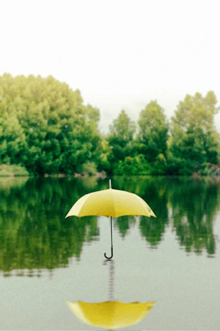yellow umbrella on surface of water at daytime