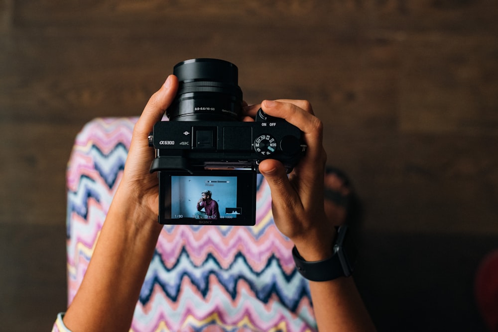 person holding black DSLR camera