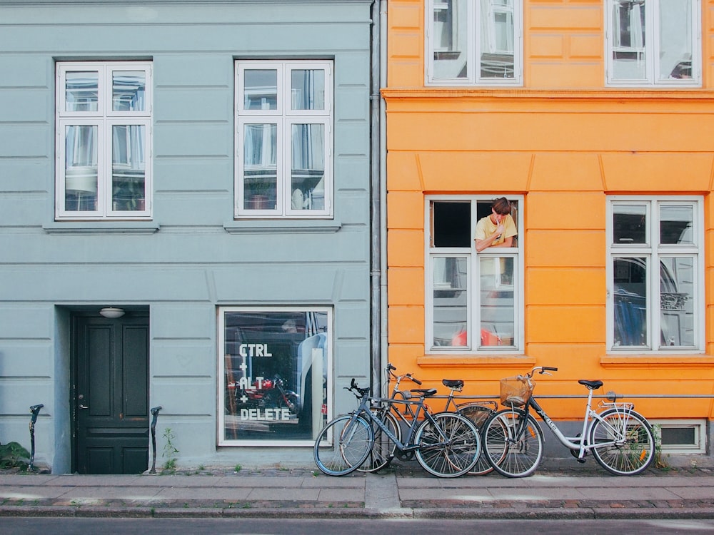 person on window looking at bicycles during daytime