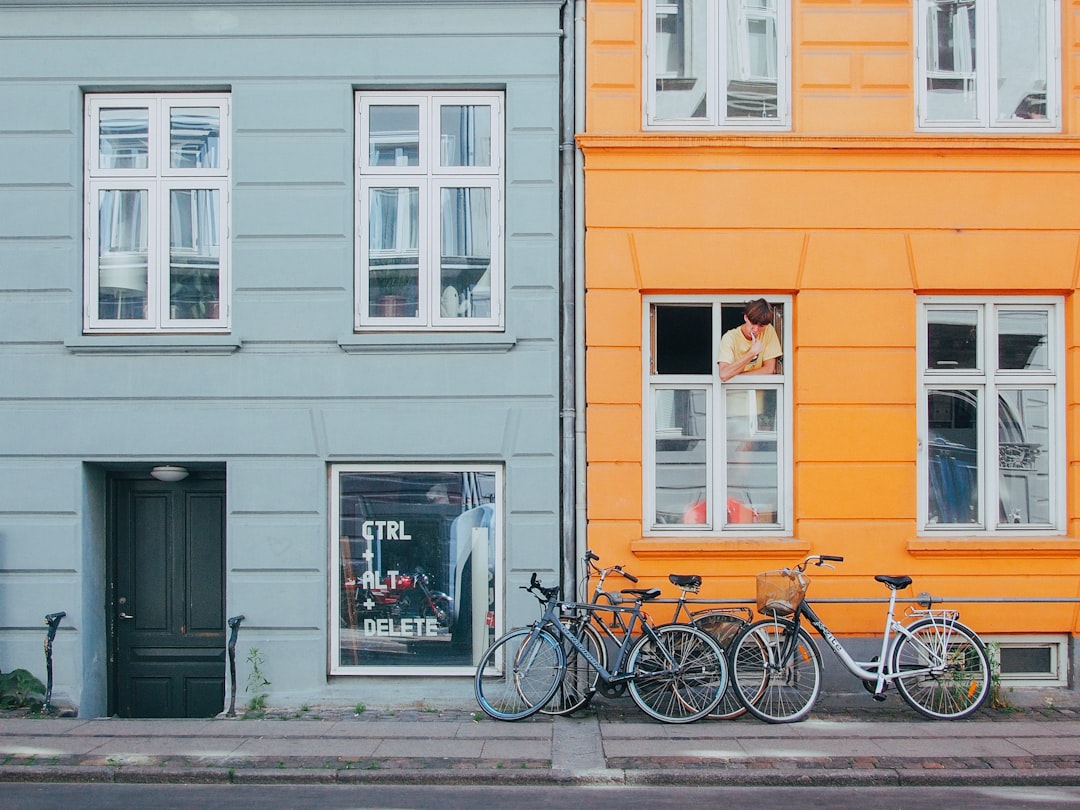 person on window looking at bicycles during daytime