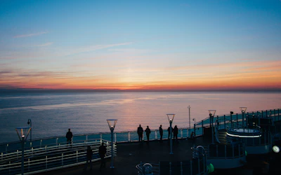 A panoramic view of the rooftop deck overlooking Lake Travis at sunset, set up for a wedding ceremony.