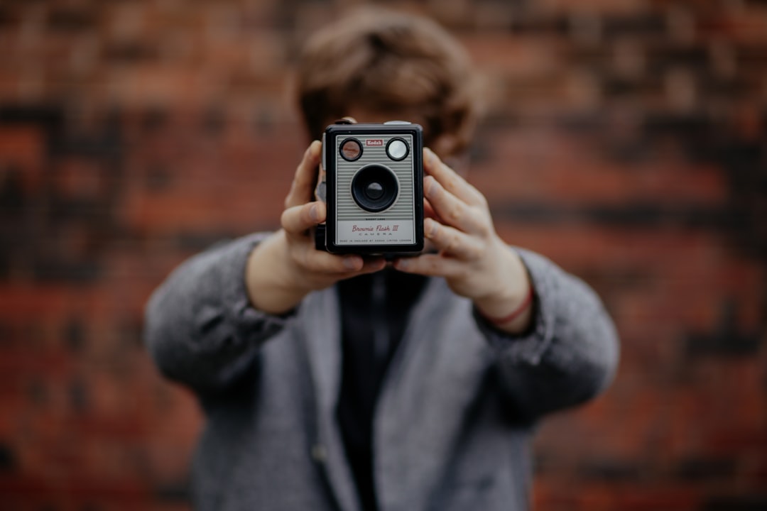 selective focus photography of person holding grey and black camera