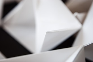 Abstract shapes with sharp angles and clean lines in a minimalist composition. The fold and interplay of light and shadow create a geometric and modern aesthetic.