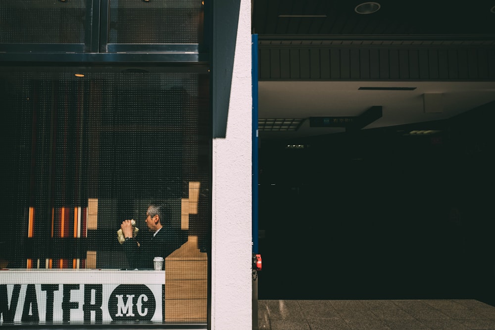 person dining inside establishment with glass wall during daytime