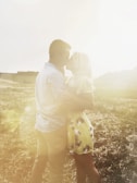 A couple embracing in a sunlit field during their prenup photo session.