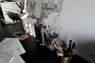 An artist’s workspace with laser engraving tools and witchy sketches.