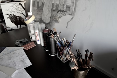 An artist’s workspace showcasing sketches and painted book covers.