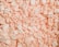 A collection of white and light pink packing peanuts densely packed together, creating a textured surface with curled and cylindrical shapes.