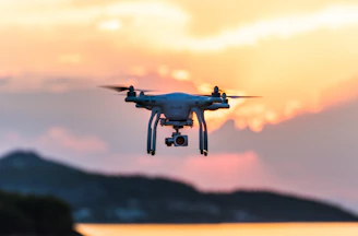 A drone capturing vibrant aerial footage over a cityscape at sunset.