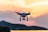 Drone capturing a stunning sunset over a city skyline.