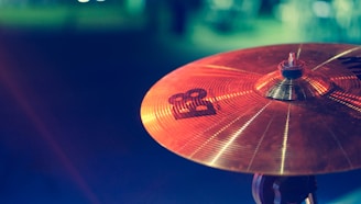 Close-up of a deep blue steel tongue drum with warm copper accents resting on a soft fabric.