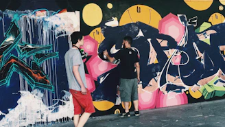 Hands painting a colorful mural together symbolizing teamwork and creativity.