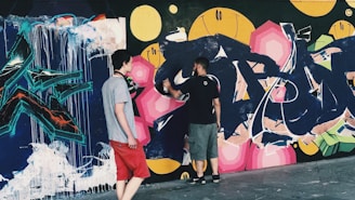 A photo of artists collaborating on a large mural.