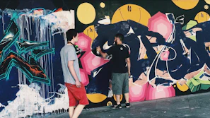 A volunteer helping a senior and child paint a mural, vibrant colors and smiles all around