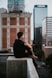 man sitting on white concrete building during daytime