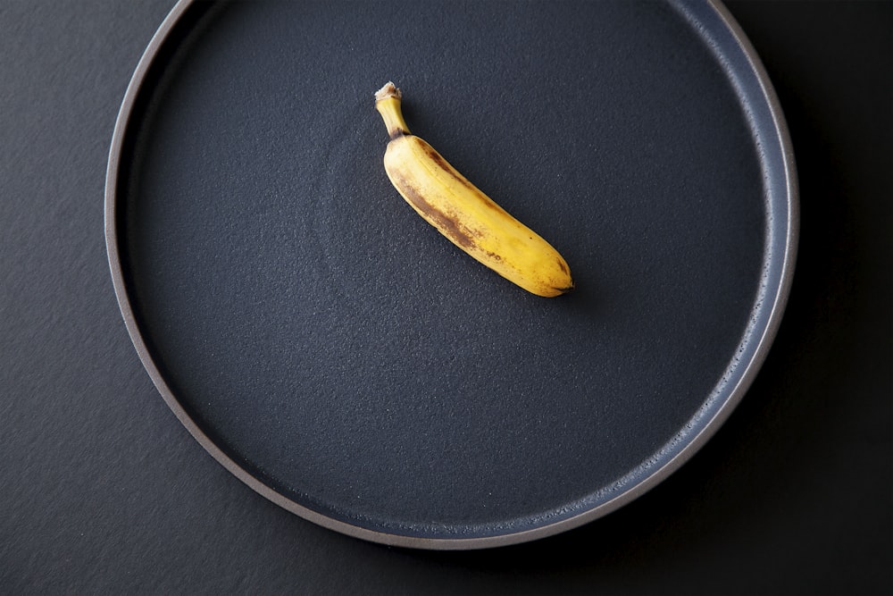 yellow banana peel on black round plate