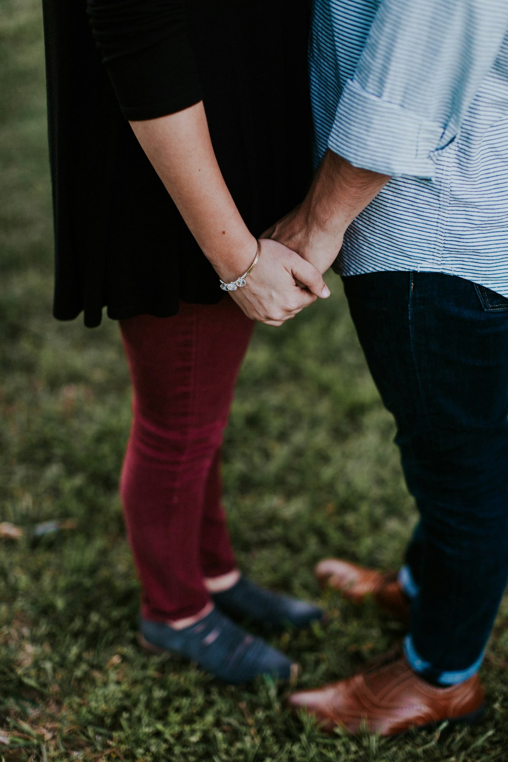 two person holding each other while standing on green grass ground