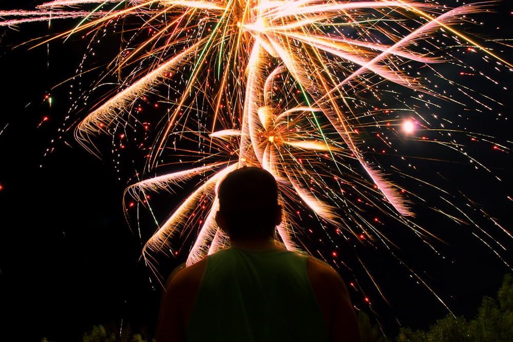man watching over firework display during nighttime