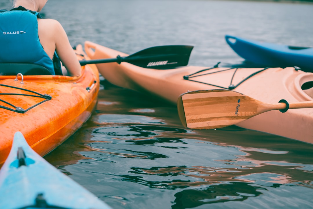 person riding on orange kayak during daytime