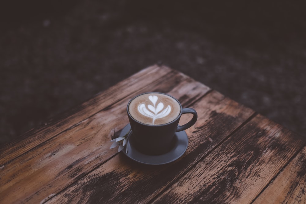 black ceramic mug with latte on table