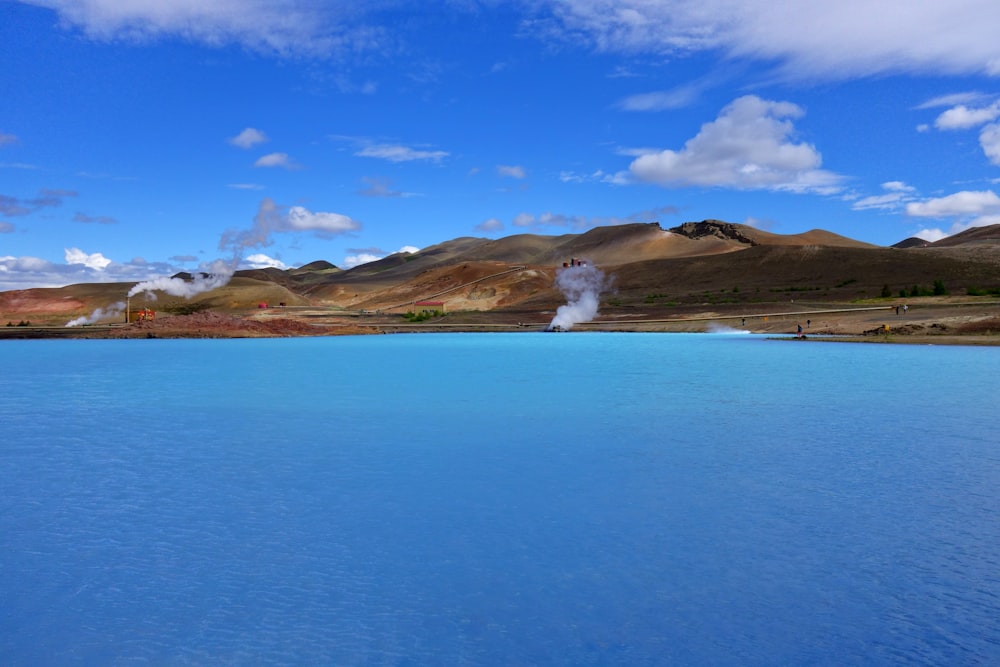 Mar azul cerca de la montaña bajo el cielo azul durante el día