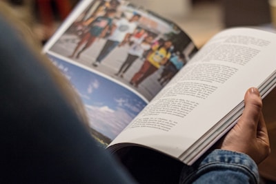 person in blue denim top reading book