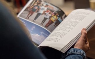 person in blue denim top reading book