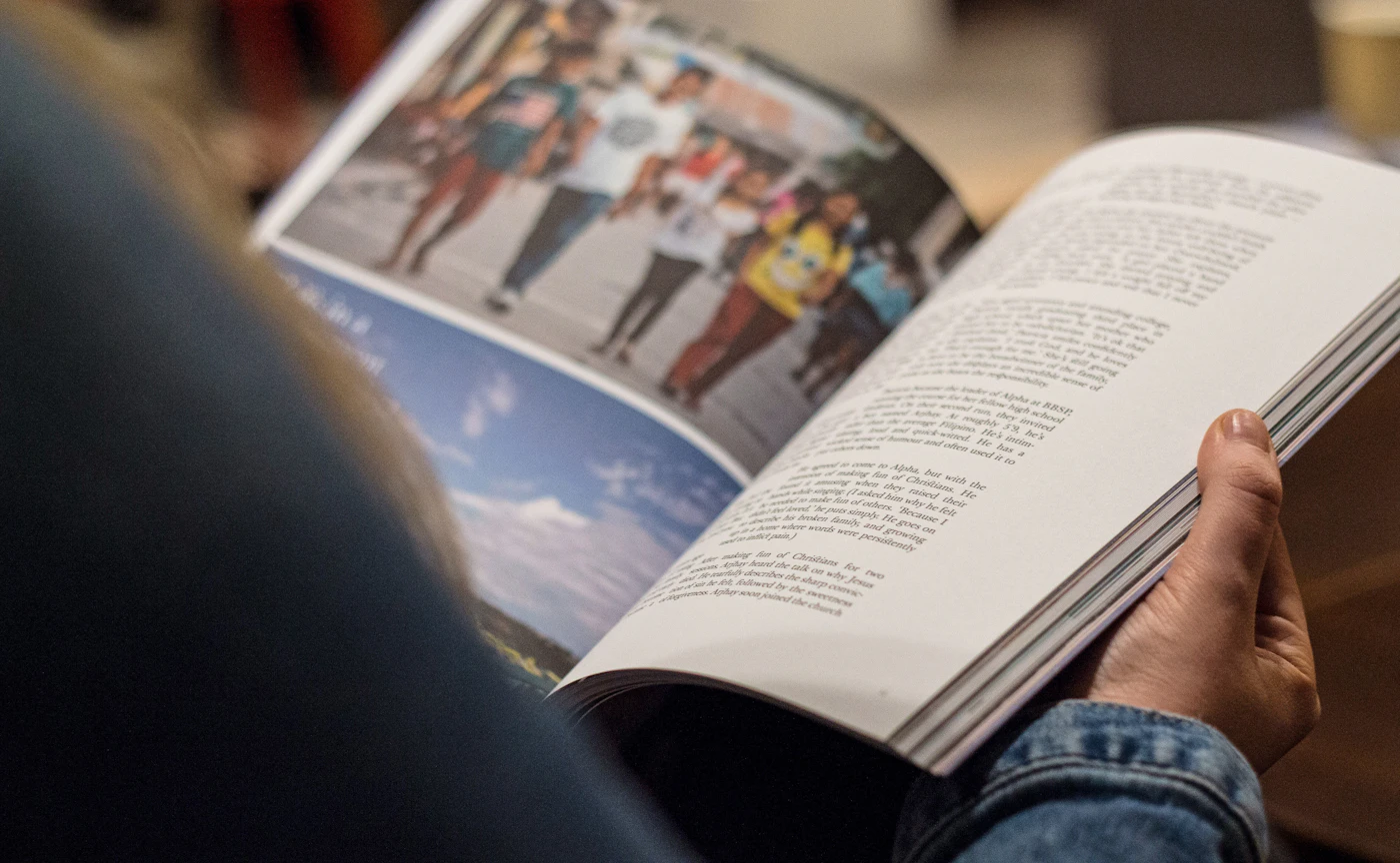 Person in blue denim top reading book