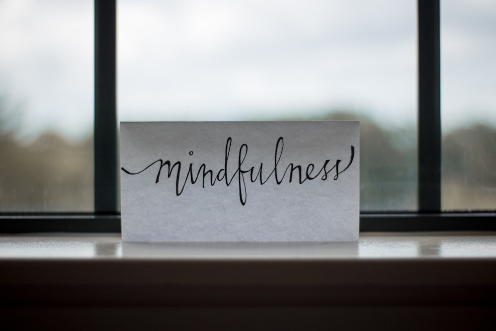 A piece of paper with “mindfulness” written in cursive