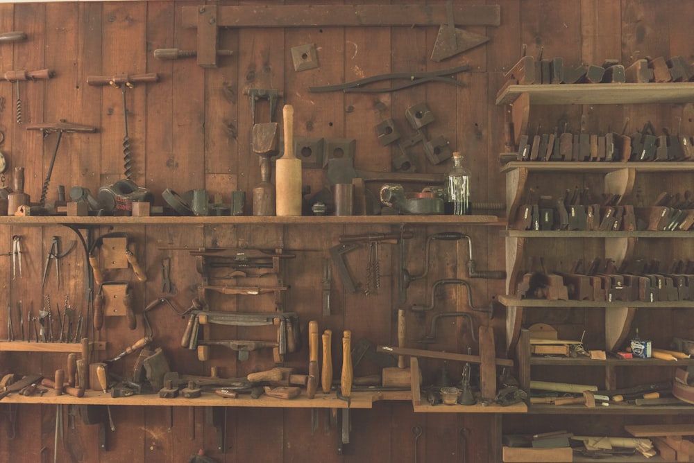 assorted hand tool lot on brown wooden shelf