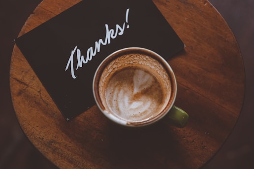 thank you card with coffee latte in teacup on table