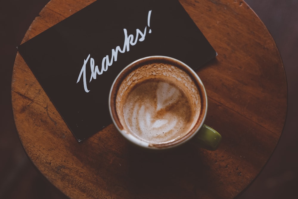 flat lay photography of coffee latte in teacup on table