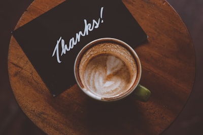 flat lay photography of coffee latte in teacup on table gratitude google meet background