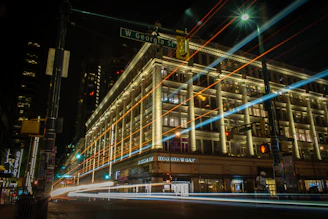 A glowing LED advertising board lighting up a busy Coquitlam street corner at dusk.
