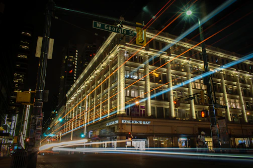 A glowing LED advertising board lighting up a busy Coquitlam street corner at dusk.