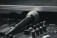Close-up of a microphone resting on a sleek karaoke machine console.