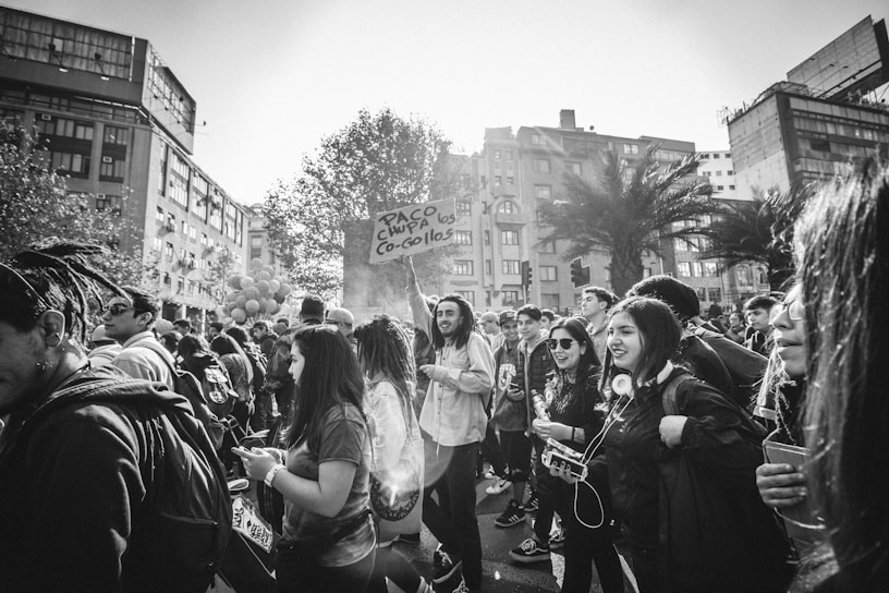 A group of participants eagerly scanning QR codes during a Scarvengers Hunt activation in a lively urban park.