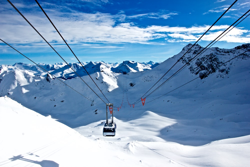 ein Skilift, der einen schneebedeckten Berg hinauffährt