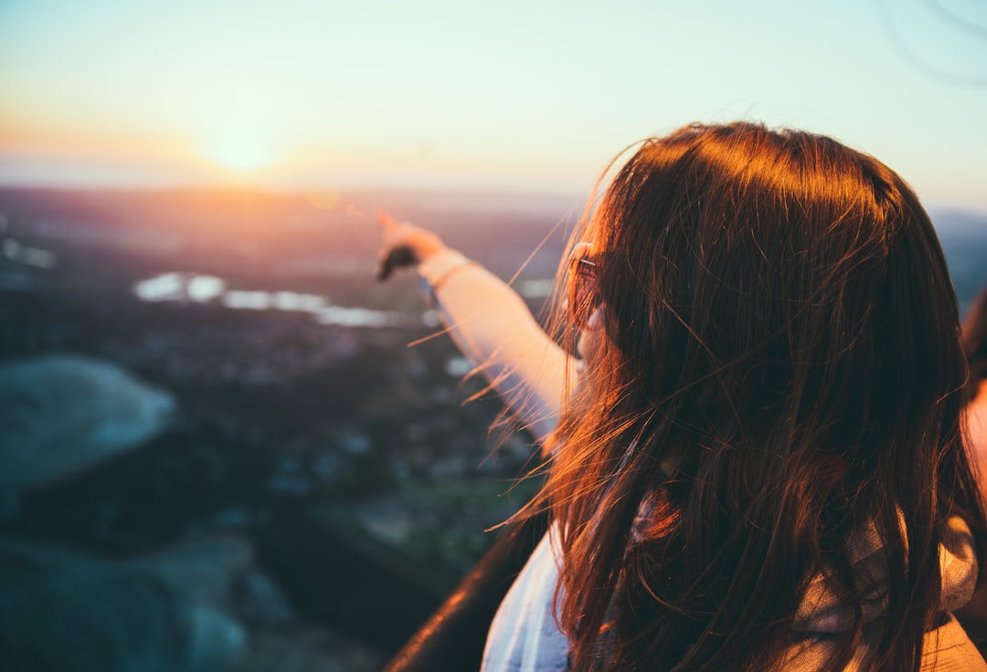 A brunette woman pointing out to the sky at Rancho Santa Fe