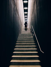 man in black pants going down stairs
