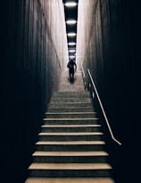 man in black pants going down stairs