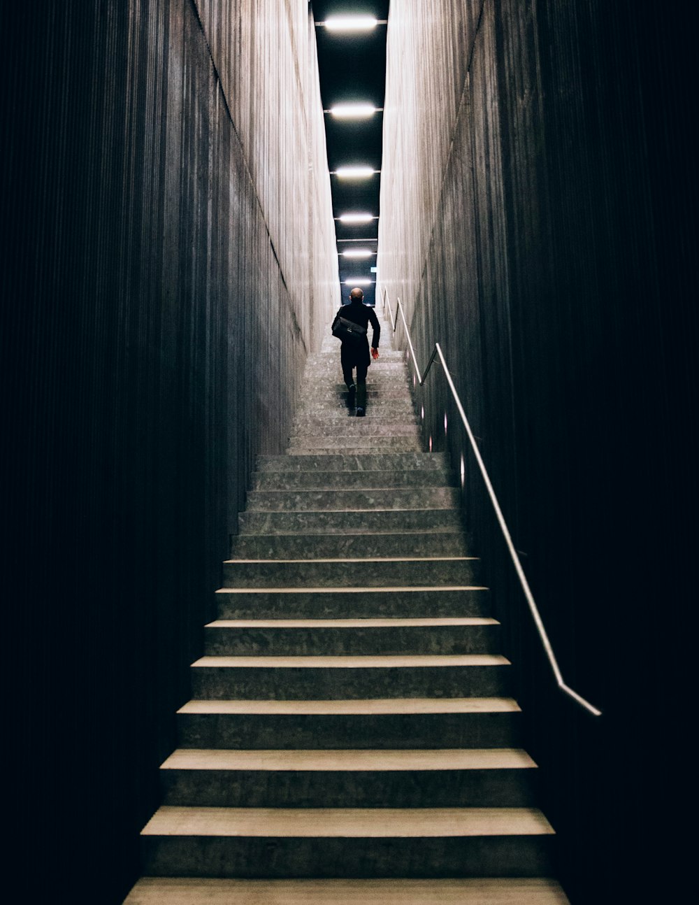 man in black pants going down stairs