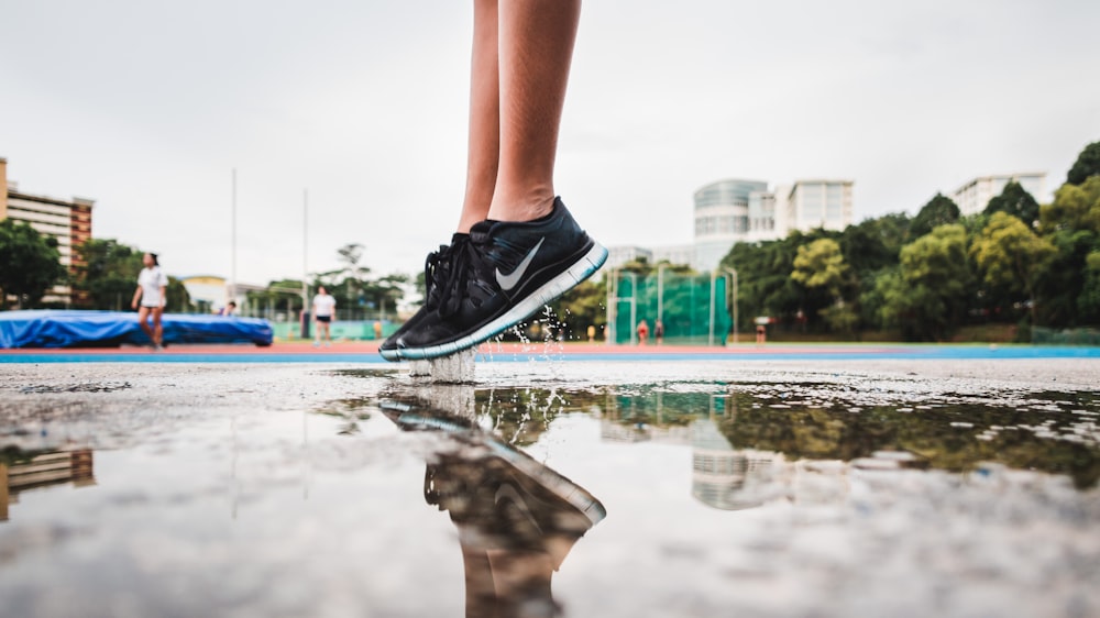 person wearing black-and-white Nike low-top sneakers