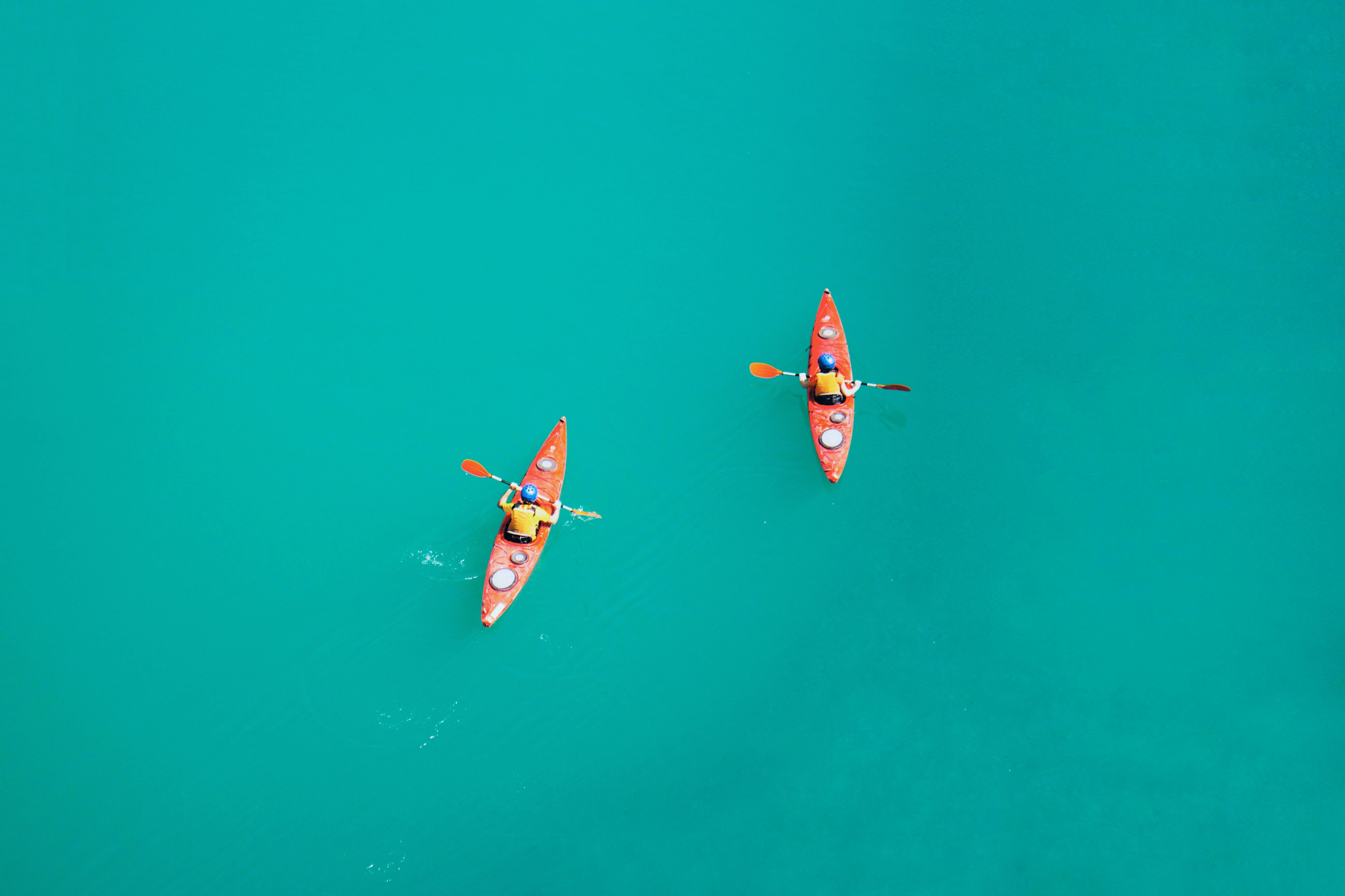 two person kayaking on open body of water