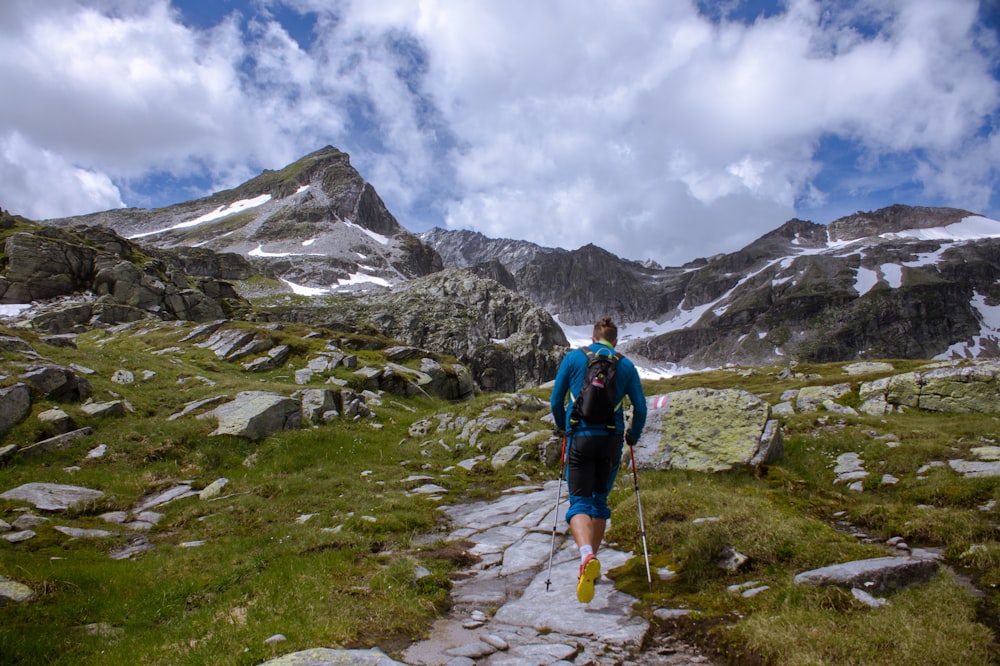 man running near rocky mountain during daytime