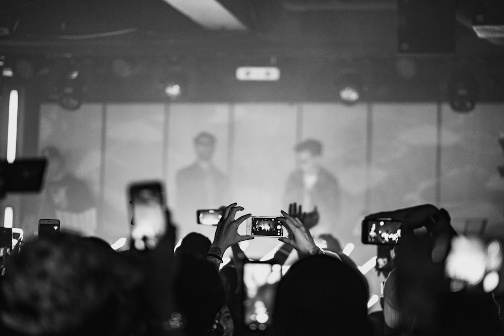 crowd taking photo of man wearing black sunglasses