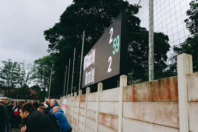 Close-up of a digital scoreboard displaying live sports scores with futuristic graphics.