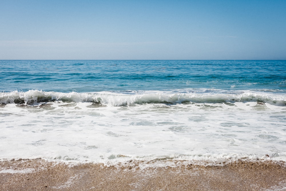 ocean waves crashing on shore during daytime