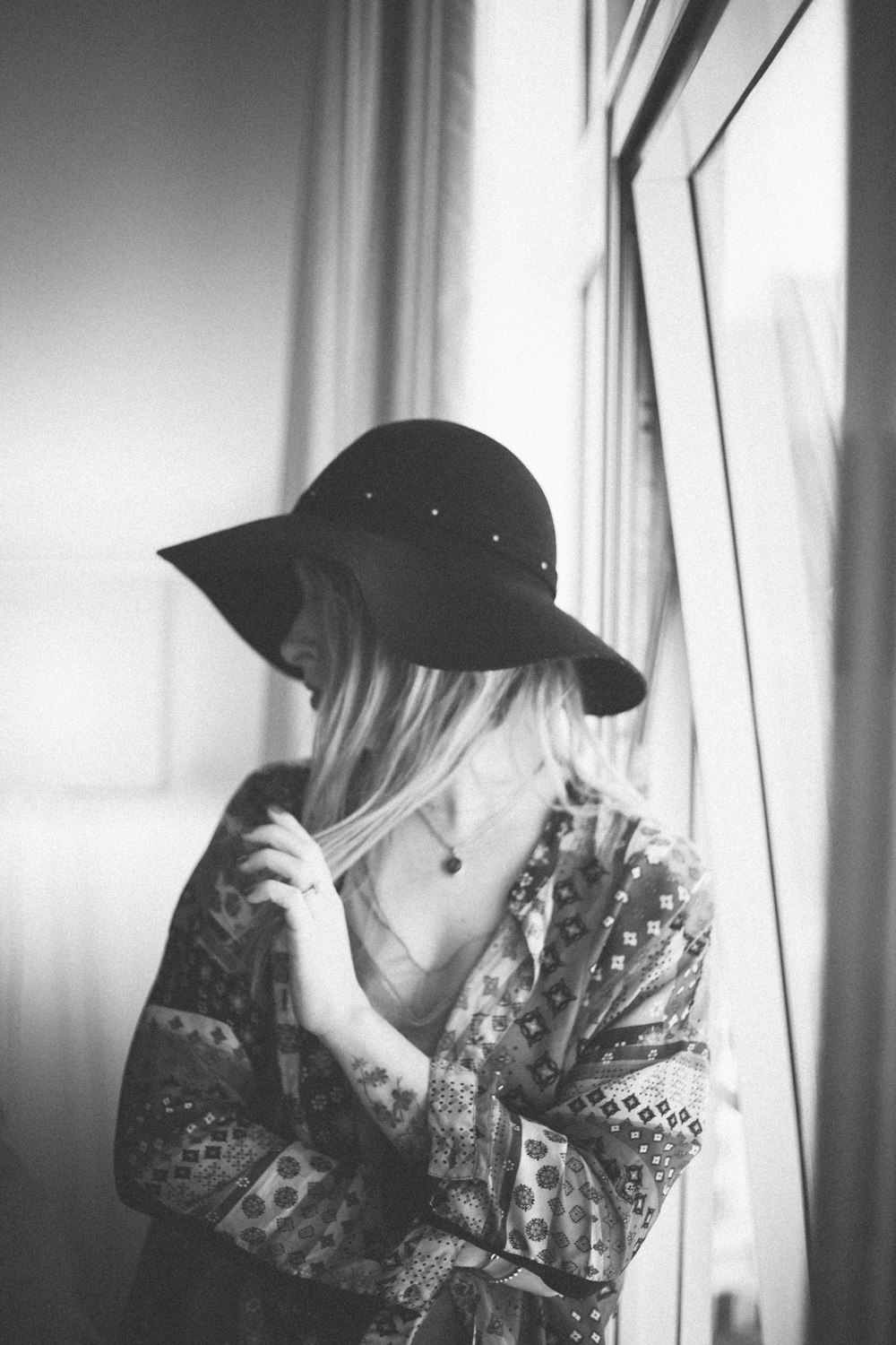 woman in black hat and white and black floral long sleeve shirt